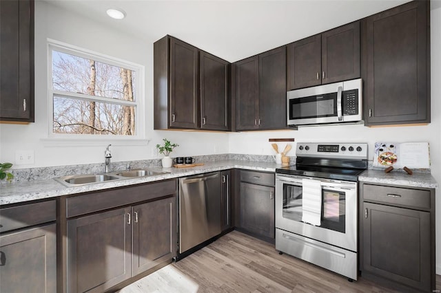 kitchen with light hardwood / wood-style flooring, sink, dark brown cabinets, and appliances with stainless steel finishes