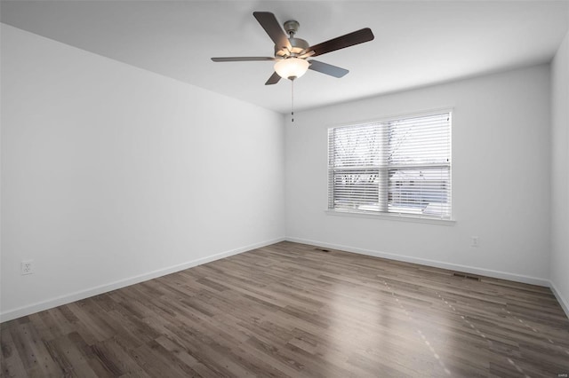 empty room featuring dark wood-type flooring and ceiling fan