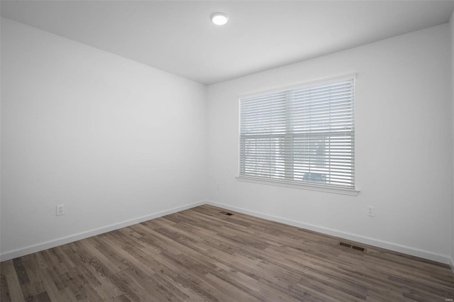 unfurnished room with dark wood-type flooring