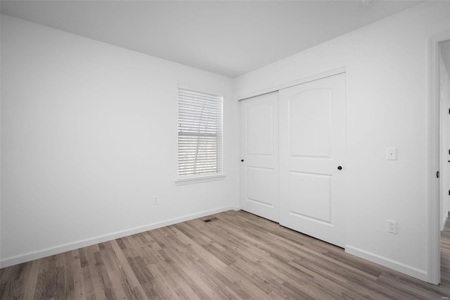 unfurnished bedroom with a closet and light hardwood / wood-style flooring