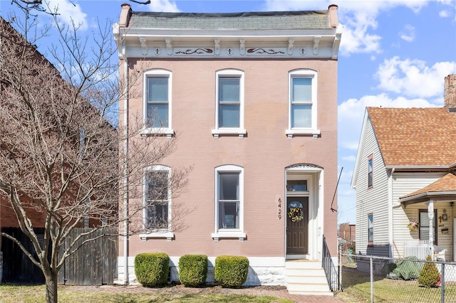 italianate house with fence and brick siding