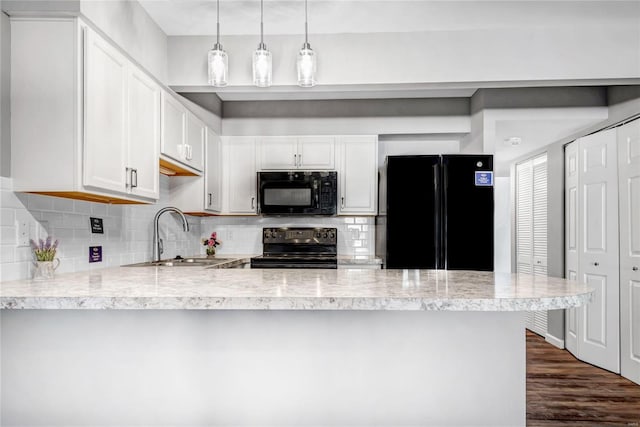 kitchen featuring hanging light fixtures, white cabinetry, sink, and black appliances