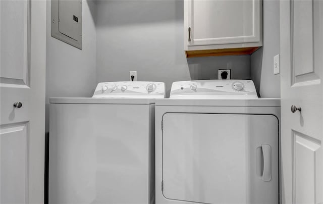 laundry room featuring cabinets, electric panel, and washer and clothes dryer