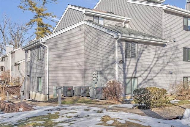 view of snow covered exterior featuring central AC unit