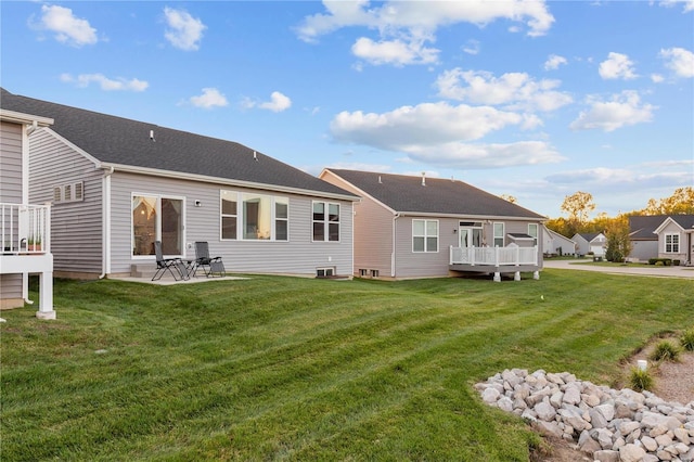 back of house featuring a yard, a patio, and a deck