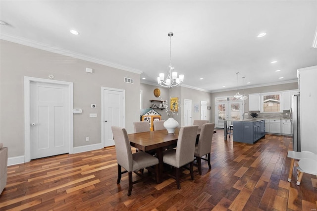 dining room with crown molding, dark wood-type flooring, and a chandelier