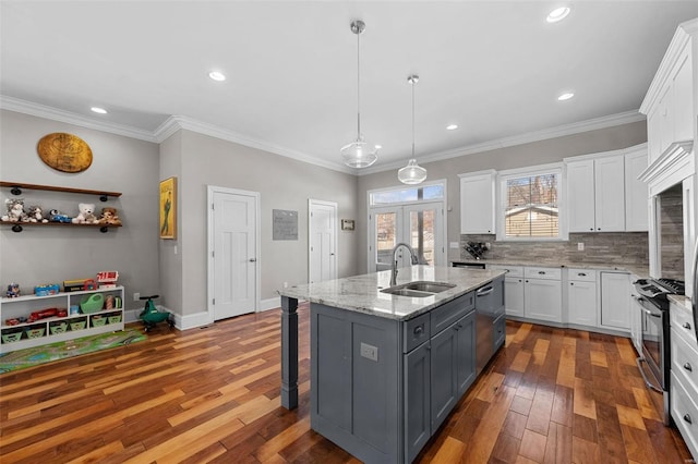 kitchen featuring sink, gray cabinetry, decorative light fixtures, an island with sink, and white cabinets