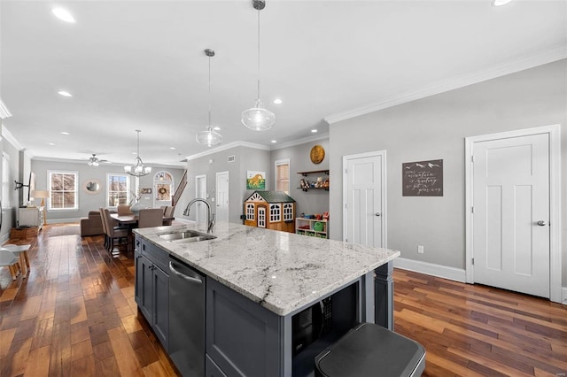 kitchen featuring dishwasher, sink, a kitchen island with sink, and decorative light fixtures