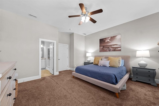 carpeted bedroom with ensuite bath and ceiling fan