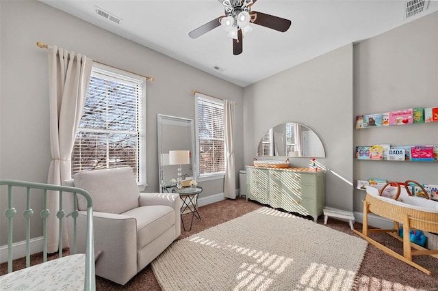 bedroom with a nursery area, ceiling fan, and carpet flooring