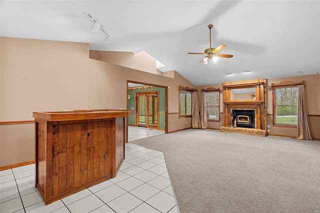 carpeted living room with ceiling fan, lofted ceiling, a fireplace, and track lighting