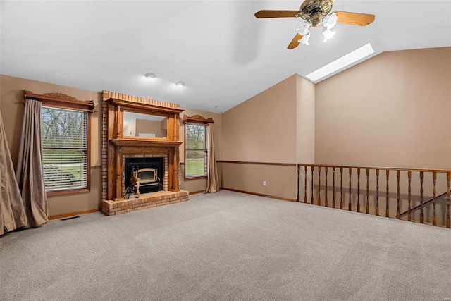 unfurnished living room featuring lofted ceiling with skylight and carpet flooring