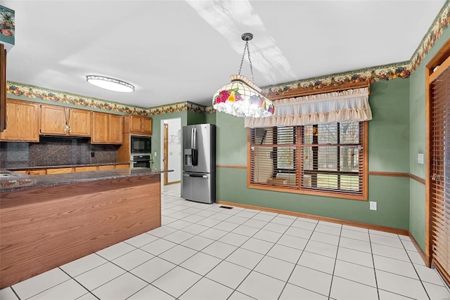 kitchen with stainless steel appliances, hanging light fixtures, light tile patterned floors, and decorative backsplash