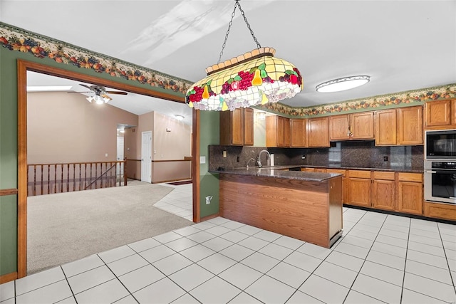 kitchen with light tile patterned flooring, lofted ceiling, black microwave, kitchen peninsula, and oven