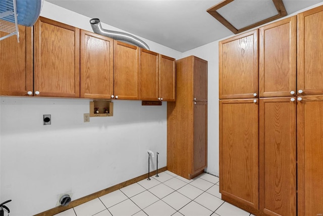 clothes washing area featuring cabinets, light tile patterned flooring, hookup for a washing machine, and hookup for an electric dryer