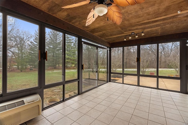 unfurnished sunroom featuring wood ceiling, track lighting, a wall mounted AC, and ceiling fan