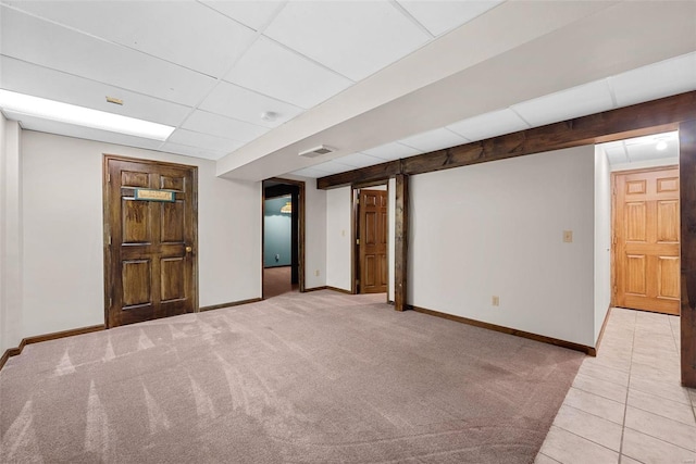 basement with light carpet and a drop ceiling