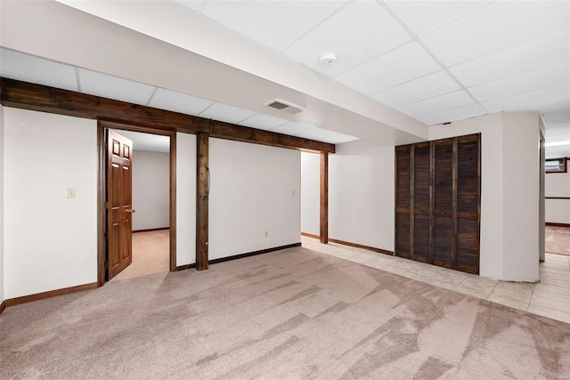 basement featuring light carpet and a drop ceiling