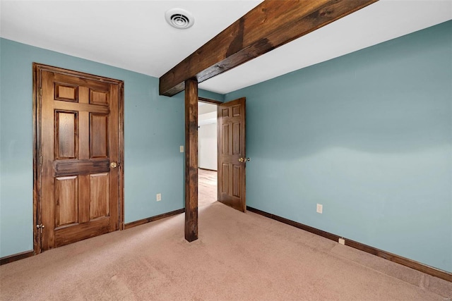 unfurnished bedroom featuring beamed ceiling and light colored carpet