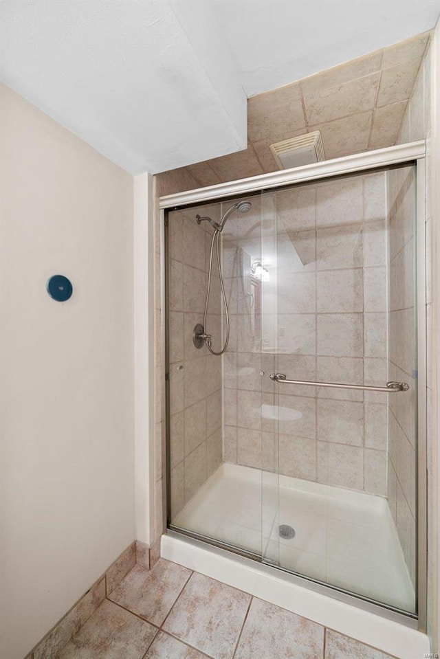 bathroom with tile patterned flooring and a shower with door