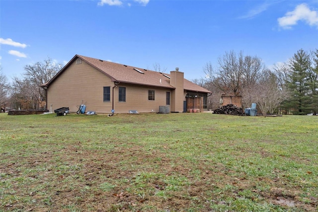 back of house featuring a yard and central air condition unit