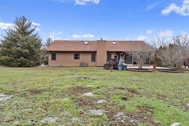 back of property with cooling unit and a lawn