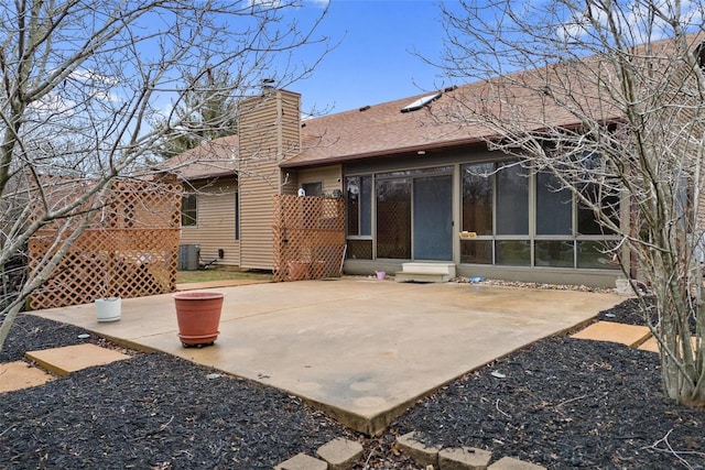 back of property featuring a sunroom, central AC unit, and a patio