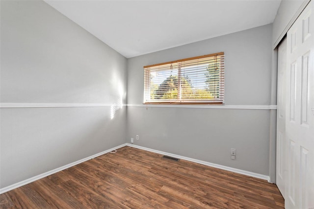 empty room featuring lofted ceiling and dark hardwood / wood-style floors