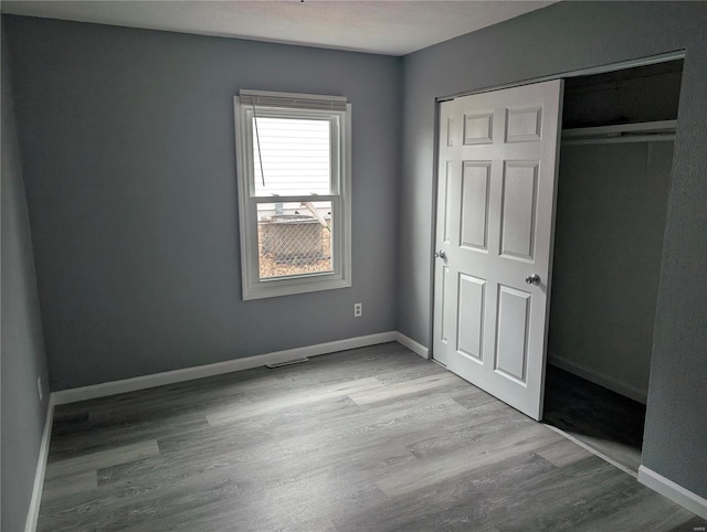 unfurnished bedroom featuring light hardwood / wood-style floors and a closet