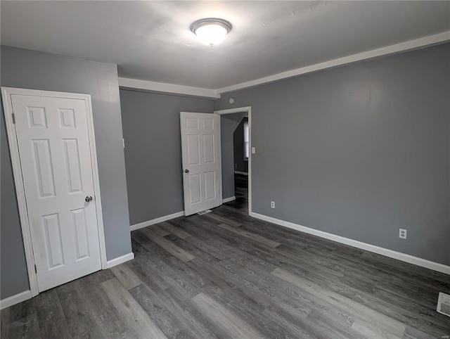 unfurnished bedroom featuring dark wood-type flooring