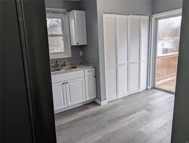 kitchen featuring light hardwood / wood-style floors, sink, and white cabinets