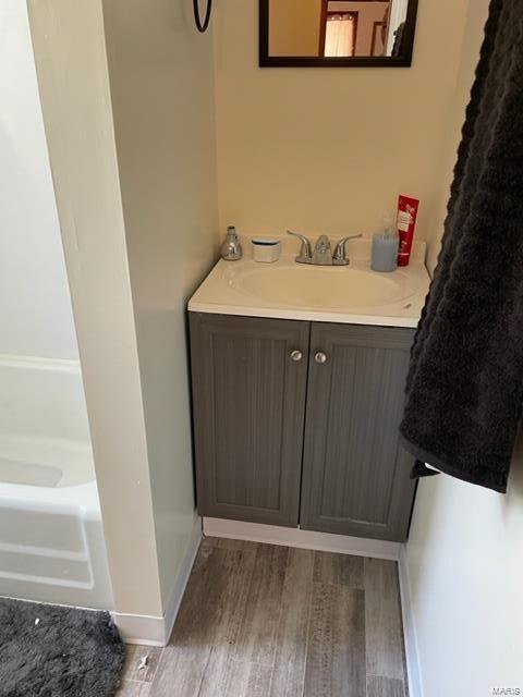 bathroom featuring vanity, a bathtub, and wood-type flooring