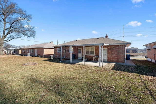 back of property featuring a patio, brick siding, and a lawn