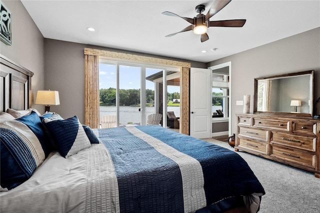 bedroom with multiple windows, carpet, access to outside, and a water view