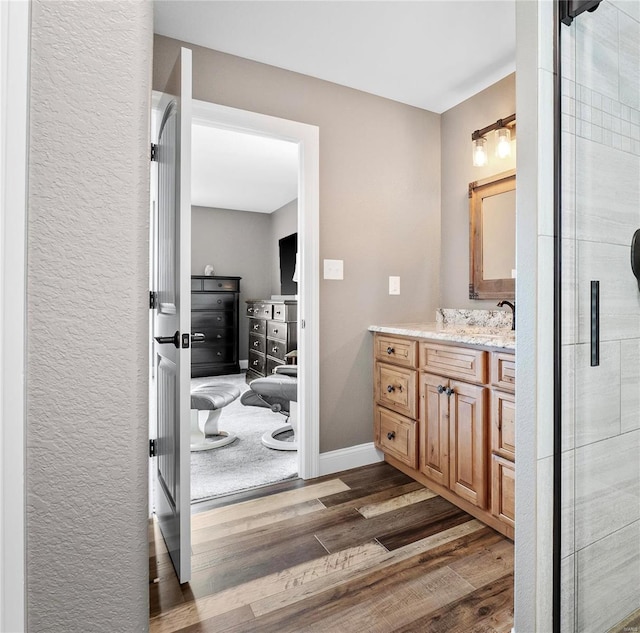 bathroom with vanity, hardwood / wood-style flooring, and walk in shower