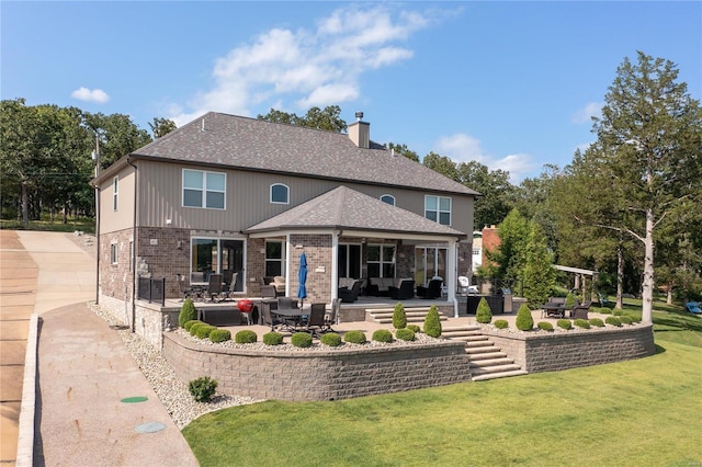 back of property featuring an outdoor living space, a patio area, and a lawn