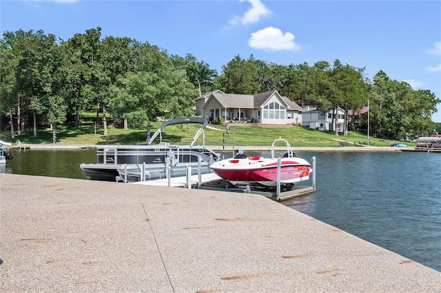 view of dock with a water view and a lawn