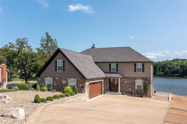 view of front of home with a garage and a water view