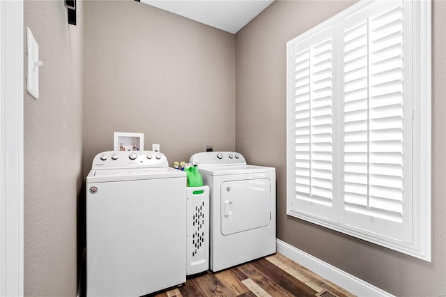 laundry room featuring washing machine and clothes dryer and dark hardwood / wood-style flooring