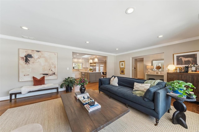 living area featuring light wood finished floors, visible vents, and crown molding