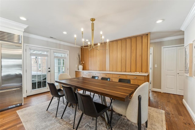 dining room with ornamental molding, french doors, baseboards, and wood finished floors