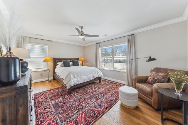 bedroom featuring ornamental molding, light wood-type flooring, visible vents, and baseboards