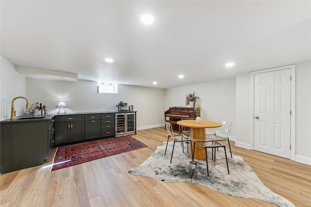 dining area with light wood finished floors, wine cooler, recessed lighting, and baseboards