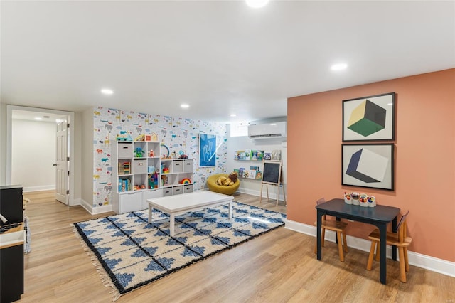 interior space with light wood-style floors, recessed lighting, a wall unit AC, and baseboards