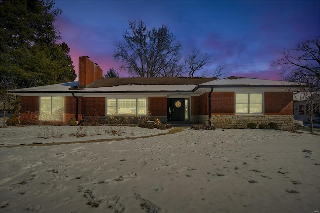 single story home with brick siding and a chimney