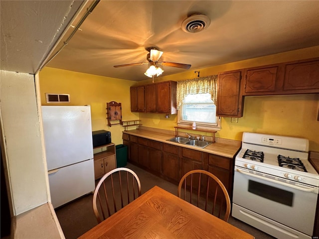 kitchen featuring ceiling fan, sink, and white appliances