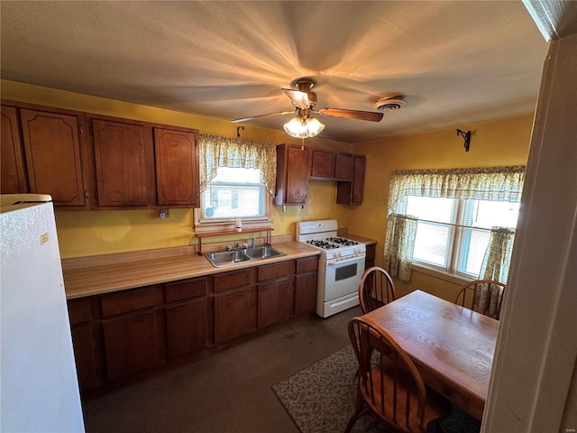 kitchen featuring sink, white appliances, and ceiling fan