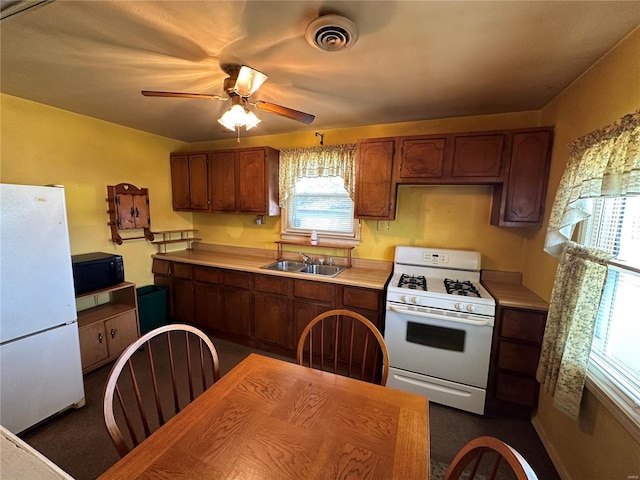 kitchen with sink, white appliances, and ceiling fan