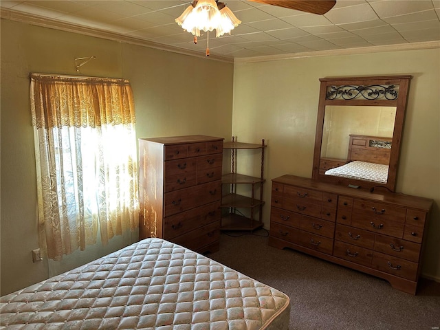 bedroom with ornamental molding and dark colored carpet