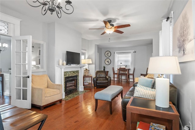 living room featuring hardwood / wood-style floors and ceiling fan with notable chandelier